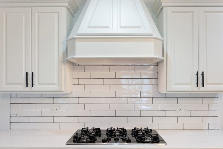 kitchen counter with white tile backsplash
