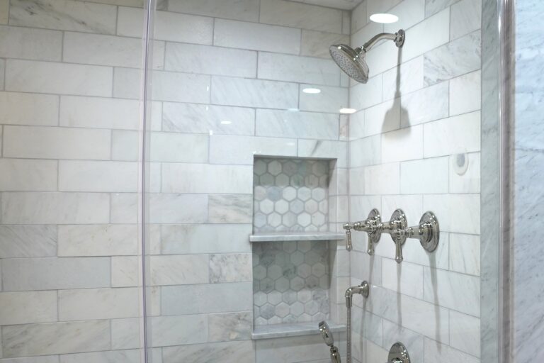 bathroom shower with white tile walls
