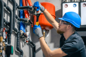 Plumber adjusting pipes with wrench